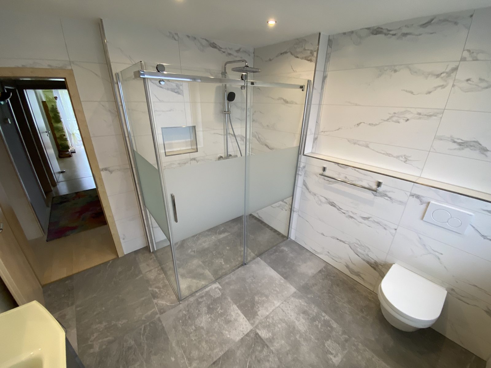 Walk-in-Dusche mit Marmoroptik und Schiebetür